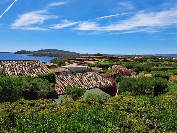 A coastal village with terracotta-roofed buildings, lush greenery, and a clear blue sky. - Villa 'Molara' with Sea View, Private Terrace, and Air Conditioning (san teodoro)