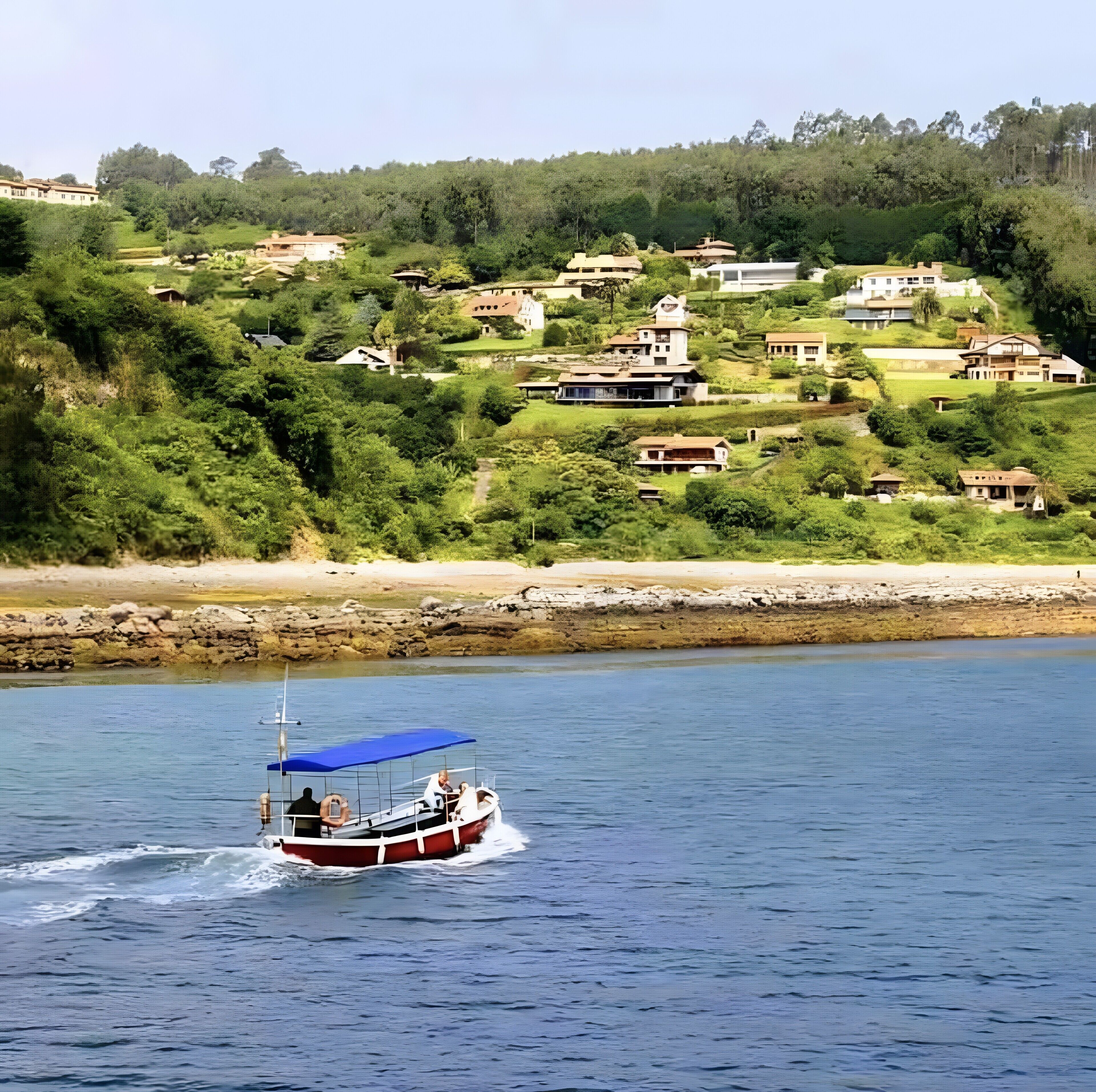 A boat on a calm body of water with houses on a hillside in the background.