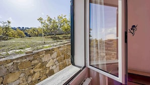 Ein Zimmer mit Stehwänden, einem Fenster mit Blick auf Bäume und einen klaren Himmel.