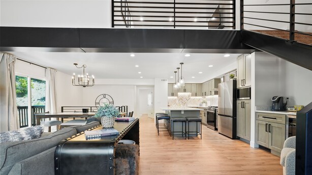 Een moderne keuken met een centraal eiland, barkrukken en een zithoek met een bank en tafel.