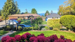 Un quartier résidentiel avec des maisons, une voiture garée et une pelouse bien entretenue.