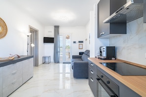 A modern kitchen with a built-in oven, a microwave, and a coffee machine.