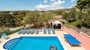 A swimming pool with sun loungers, a table tennis table, and a view of the surrounding landscape. - Holiday Home 'Azzure' with Sea View, Wi-Fi and Air Conditioning (Lloret de Mar)