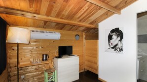 Una habitación con paneles de madera, un escritorio, una silla y un aire acondicionado instalado en la pared.