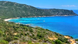 Un paysage côtier avec une plage, des bateaux et un phare.