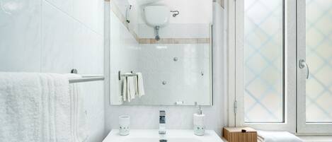 A bathroom with a white sink, mirror, and towel rack.