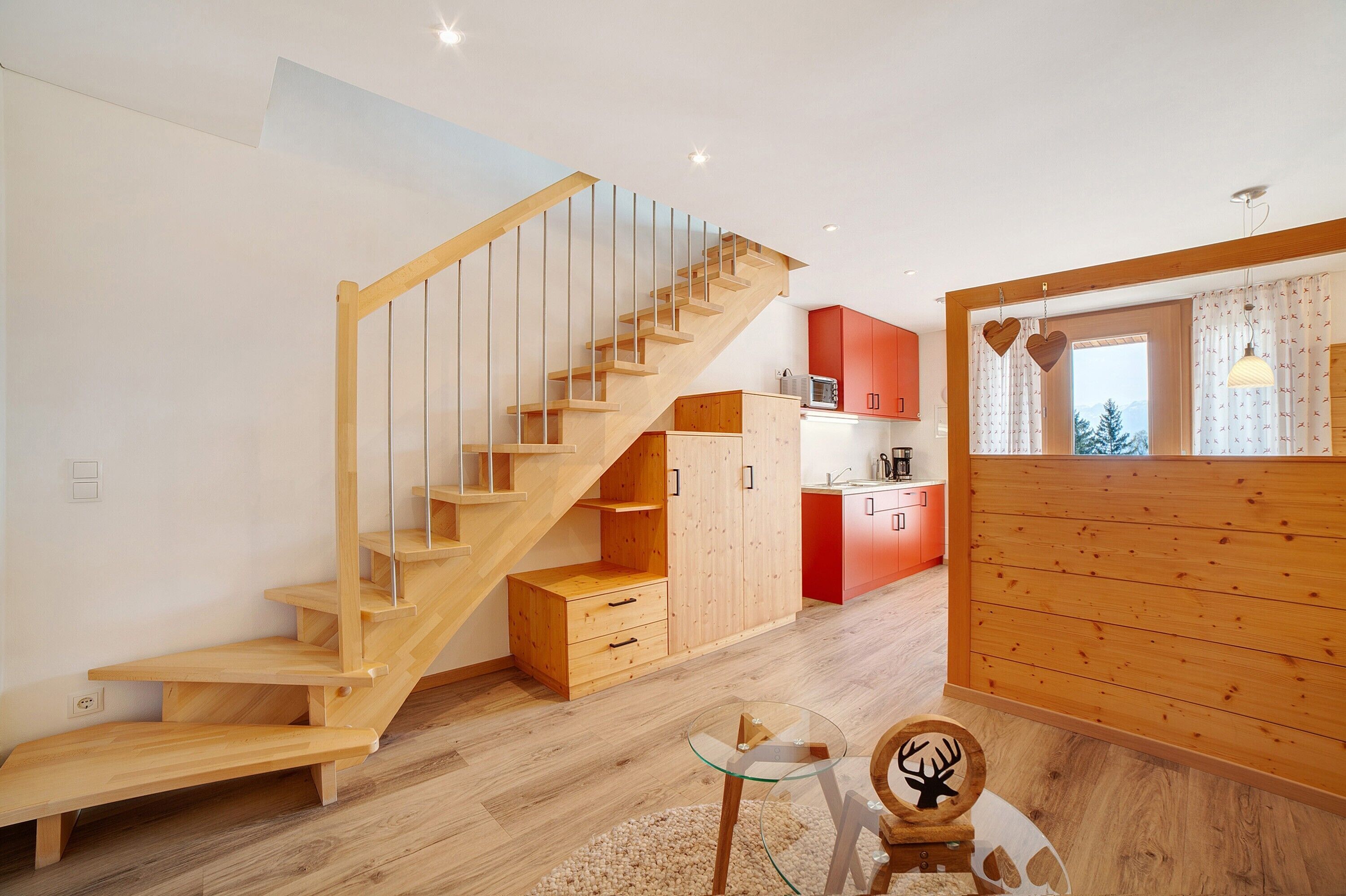 Un intérieur moderne avec un escalier en bois, un coin cuisine et un espace repas.