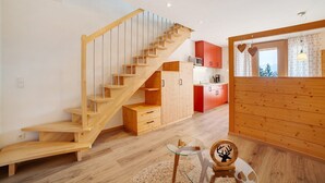 Ein modernes Interieur mit einer Holztreppe, einer Küchenzeile und einem Essbereich.
