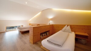 Ein modernes Schlafzimmer mit Holz-Kopfteil, Nachttisch, Lampe und Blick ins Freie.
