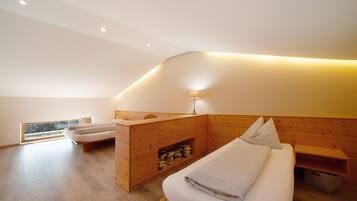 Une chambre moderne avec une tête de lit en bois, une table de chevet, une lampe et une vue sur l’extérieur.