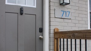 A grey front door with a window, a mailbox, and a house number 717 on the wall. - Charming 2-bedroom townhome in Raleigh with AC, WiFi (Raleigh)