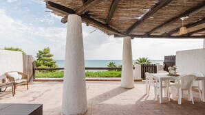 A covered patio with white chairs and a table, overlooking the sea. - Apartment 'Lumia Sole' with Sea View, Wi-Fi and Air Conditioning (Sciacca)