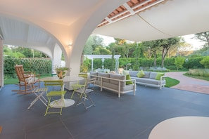 An outdoor patio with a white sofa, green chairs, and a table. - Villa 'Di Charme Ischia Porto' with Shared Terrace, Wi-Fi and Air Conditioning (Ischia)