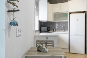 A kitchen with white cabinets, a microwave, and a refrigerator. - Holiday Home 'Buganvilla' with Wi-Fi (Barbate)
