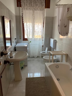 Un bagno con vasca, lavabo, WC e zona doccia.