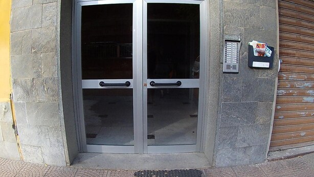 A revolving door with glass panels and a keypad lock on the wall. - Apartment 'Serravalle Shopping' with Balcony and Wi-Fi (Serravalle Scrivia)
