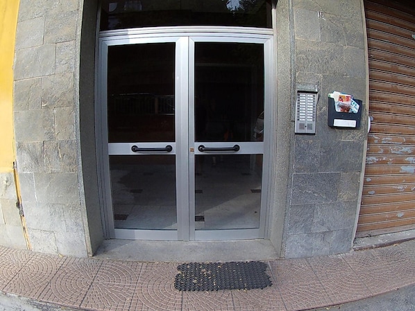 Una porta girevole con pannelli di vetro e una serratura a codice sulla parete.
