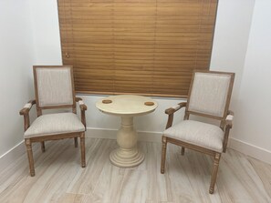 Relax in this cozy corner room with a comfortable chair and a round table.