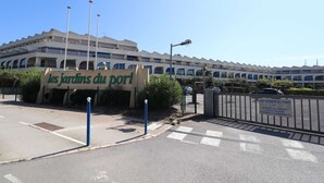 Ein Gebäude mit einem Schild, das 'les jardins du port' zeigt, und einem befestigten Eingang.