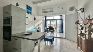 Een moderne keuken met een eethoek, een kleintje tafeltje en uitzicht op de stad.