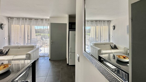 Ein kompaktes Hotelzimmer mit Küchenzeile, Essbereich und einem Balkon mit Blick.