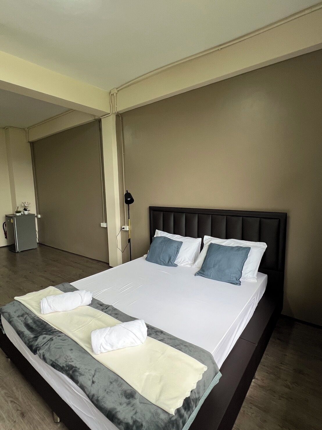 A hotel room with a large bed, a desk, and a chair.