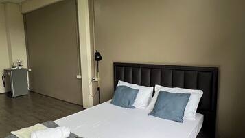 A hotel room with a large bed, a desk, and a chair.