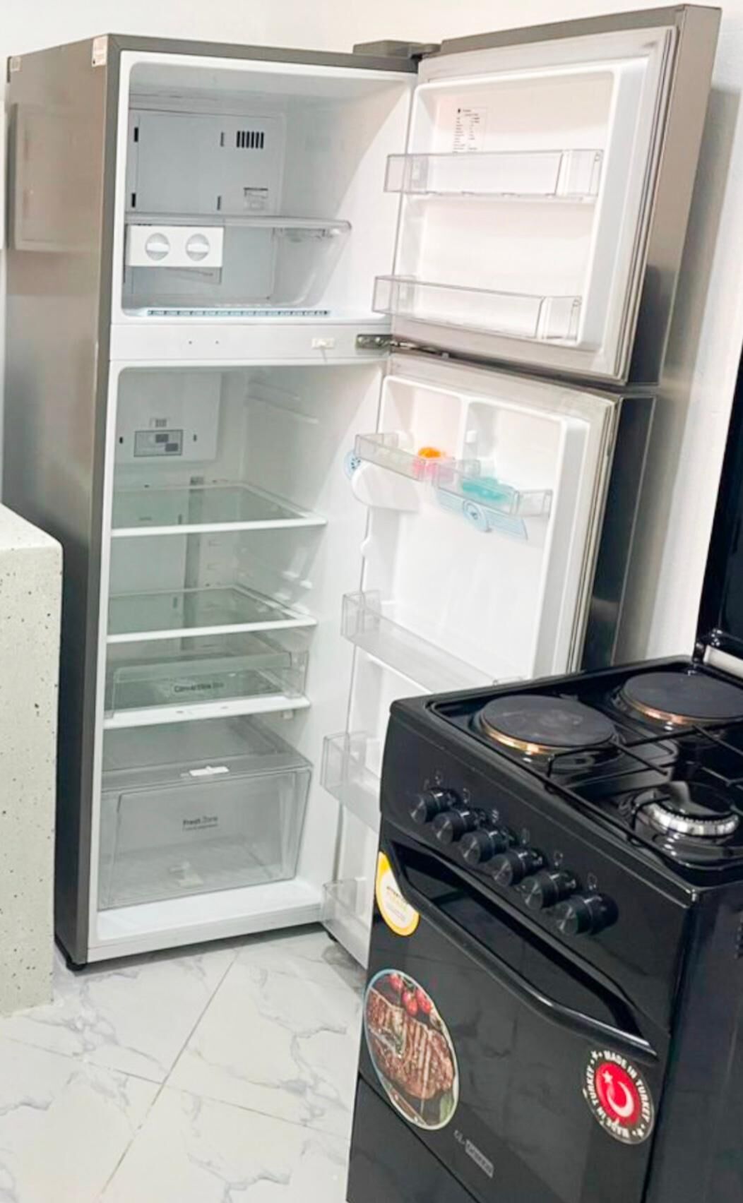 A kitchen with a double-door refrigerator, a stove, and a microwave.