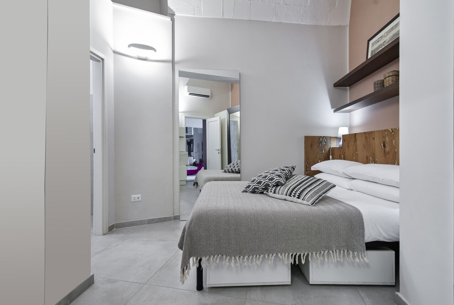 Ein modernes Schlafzimmer mit einem Bett, Nachttischen und einem Spiegel.
