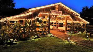 A rustic wooden building with string lights and a sign reading "The McKinley Pavilion." - Cozy cabin and TUBING!  Swim, Horses, hiking, lake-3 mi from Helen! Relax!  (Cleveland)