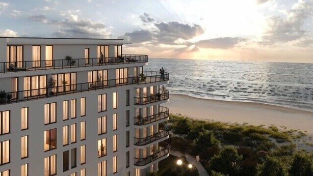 Ein mehrstöckiges Hotel mit Balkonen mit Blick auf einen Strand.