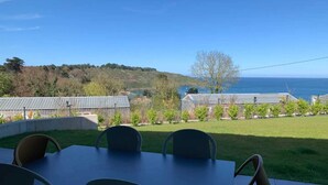 Un pati amb taula i cadires que donen a una vista del mar.