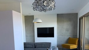 Zona de menjador moderna amb una taula rodona, cadires blanques, una ampolla de vi i un menú.