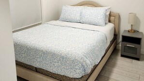Un dormitorio con cama, mesita de noche y lámpara.