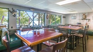Un restaurant avec des banquettes, des tables et une vue sur l’extérieur.
