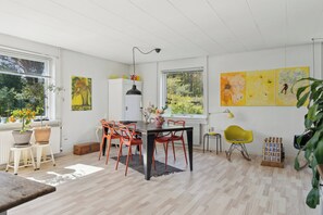A dining area with a table, chairs, and potted plants. - A peaceful oasis near the beach and forest (Hundested)