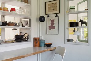 A kitchen with white shelves, a wooden countertop, and various kitchenware. - A peaceful oasis near the beach and forest (Hundested)