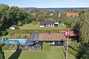 A residential property with a swimming pool, outdoor seating, and a flag. - Holiday paradise with pool near Havnsø Beach (Føllenslev)