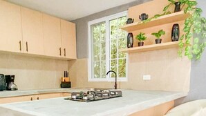 Une cuisine moderne dotée d’un îlot central, de tabourets de bar et d’une fenêtre offrant une belle vue.