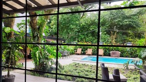 Un espace piscine avec des chaises longues et une pergola.