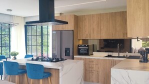 Una cocina moderna con una isla central, armarios de madera y un horno empotrado.