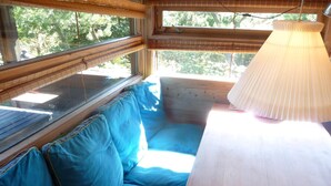 A room with a wooden bench, a table, and a window with blinds. - Cozy cottage close to the beach (Liseleje)