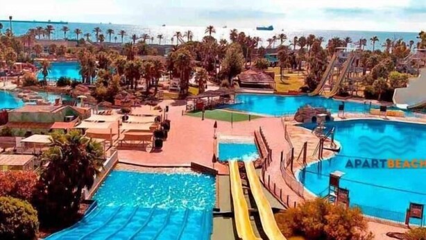 A resort with multiple swimming pools, a water slide, and palm trees. - APARTBEACH PARADIS PARK VUE SUR LA PLAGE (La Pineda)