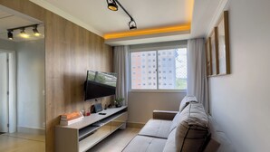 Ein modernes Wohnzimmer mit Flachbildfernseher, integriertem Unterhaltungssystem und einer Couch.