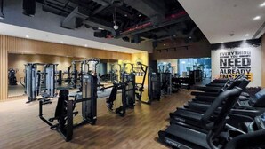 A gym with various exercise machines, treadmills, and a motivational quote on the wall.