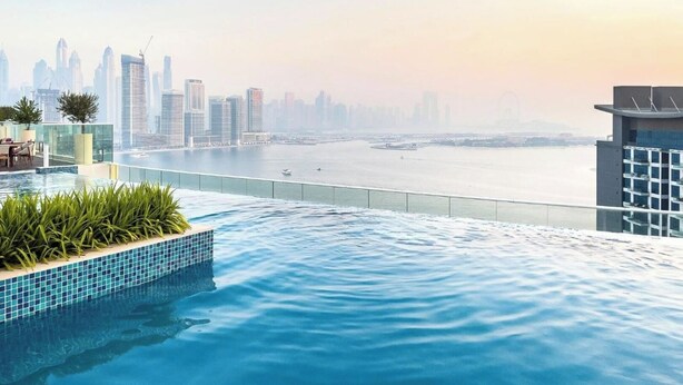 A rooftop infinity pool with a city skyline view.