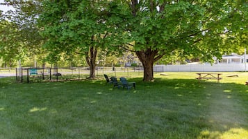A park with a picnic table, benches, and a playground area.