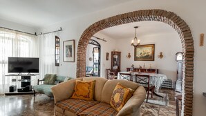 Ein Wohnzimmer mit Sofa, Fernseher und Essbereich.