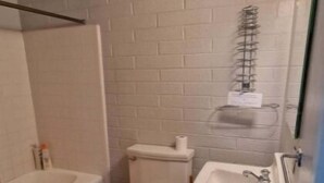 A bathroom with a toilet, sink, and bathtub.