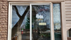A window with a sign indicating 'Lodge Lobby' and a phone number. - Family Suite - Economy (Garden City)